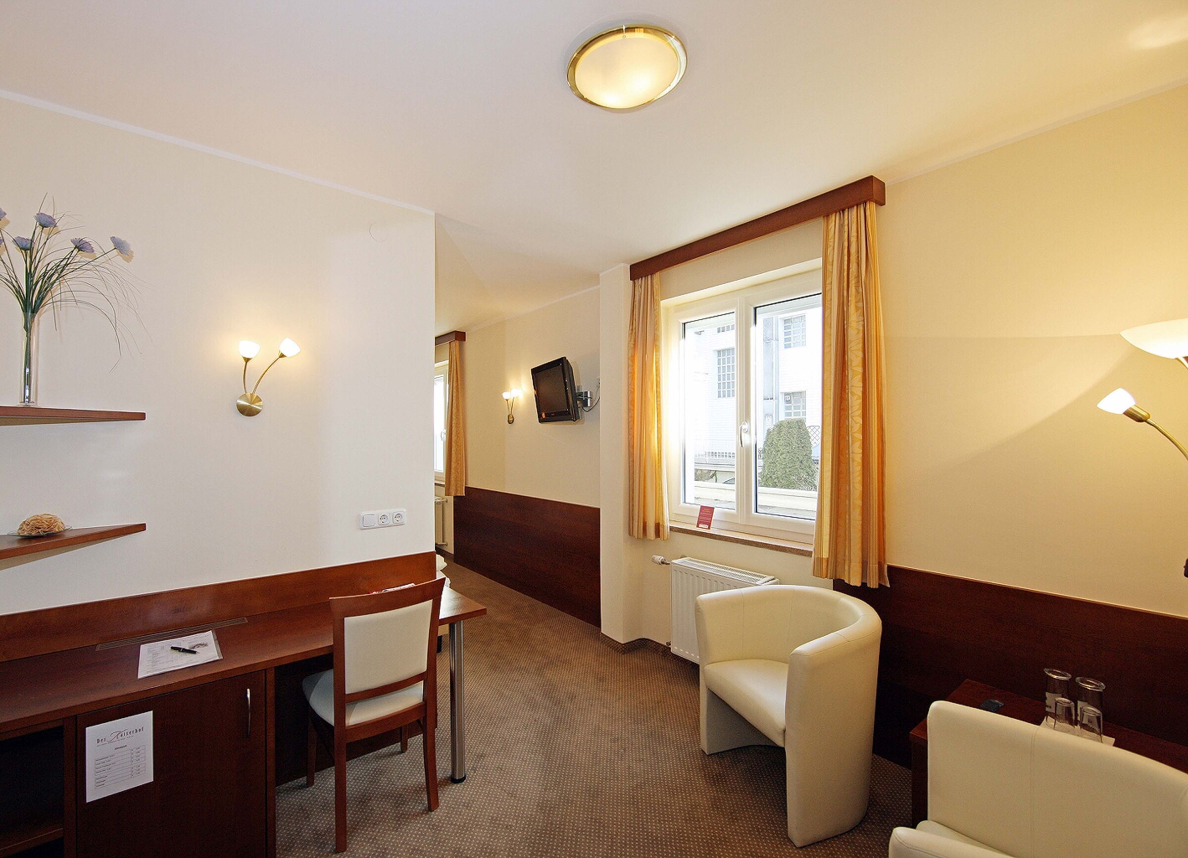 Window with curtain and desk in the Classic double room at Hotel Der Kaiserhof