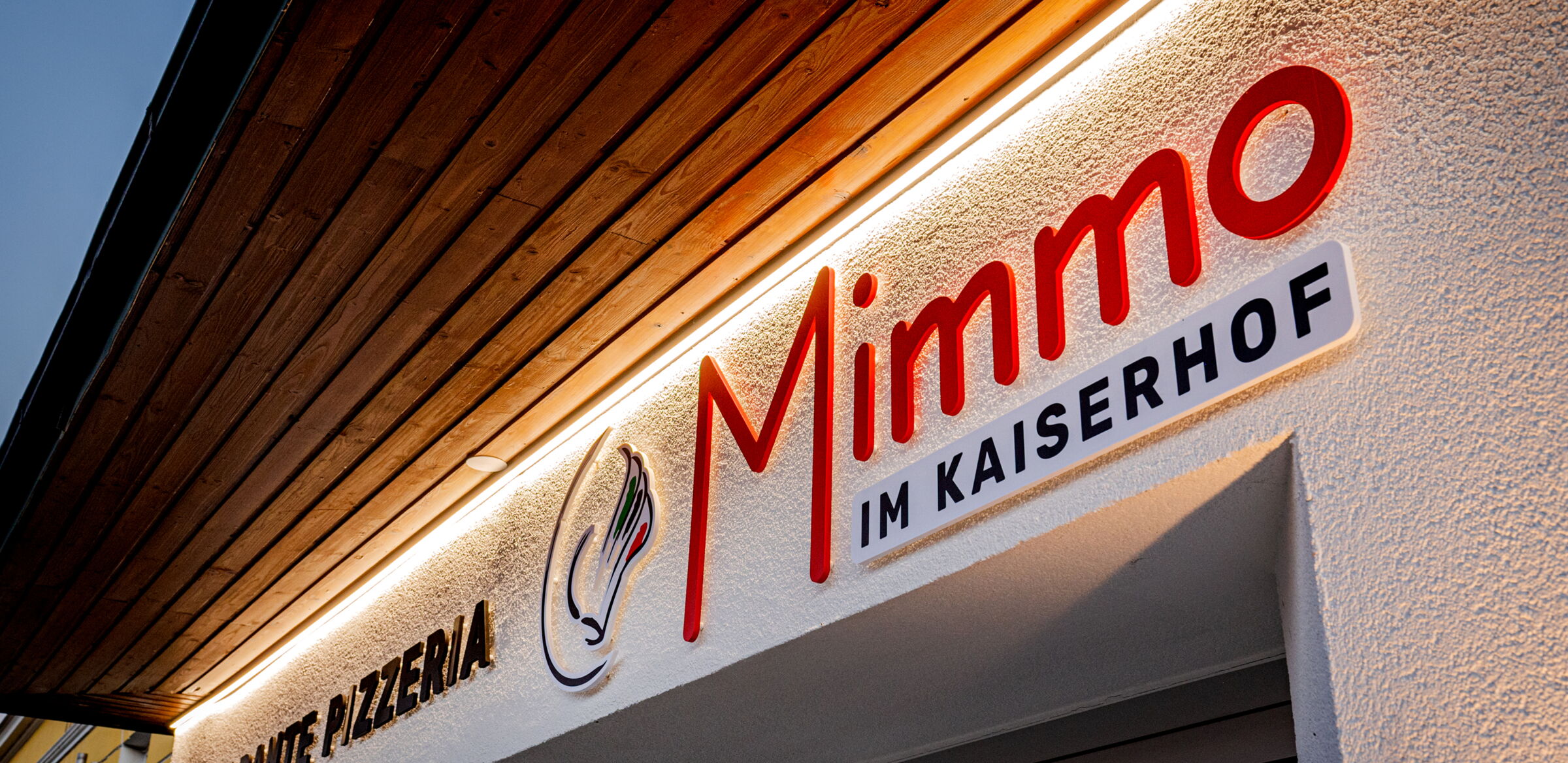 A sign with the words "ristorante pizzeria" and "Mimmo im Kaiserhof" above the entrance to the restaurant "Da Mimmo".