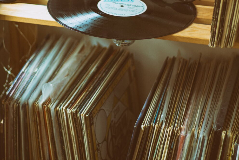 A wooden shelf with vinyl records