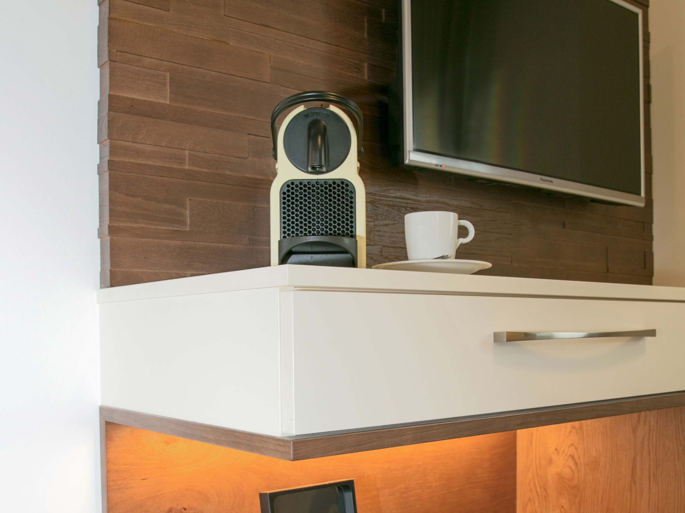 Eine Nespresso-Kaffeemaschine mit Kapseln im Wohnbereich der Junior Suite im Hotel Der Kaiserhof