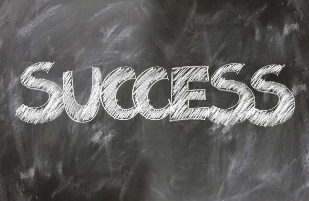 Das Wort "Success" auf einer Tafel mit Kreide geschrieben.