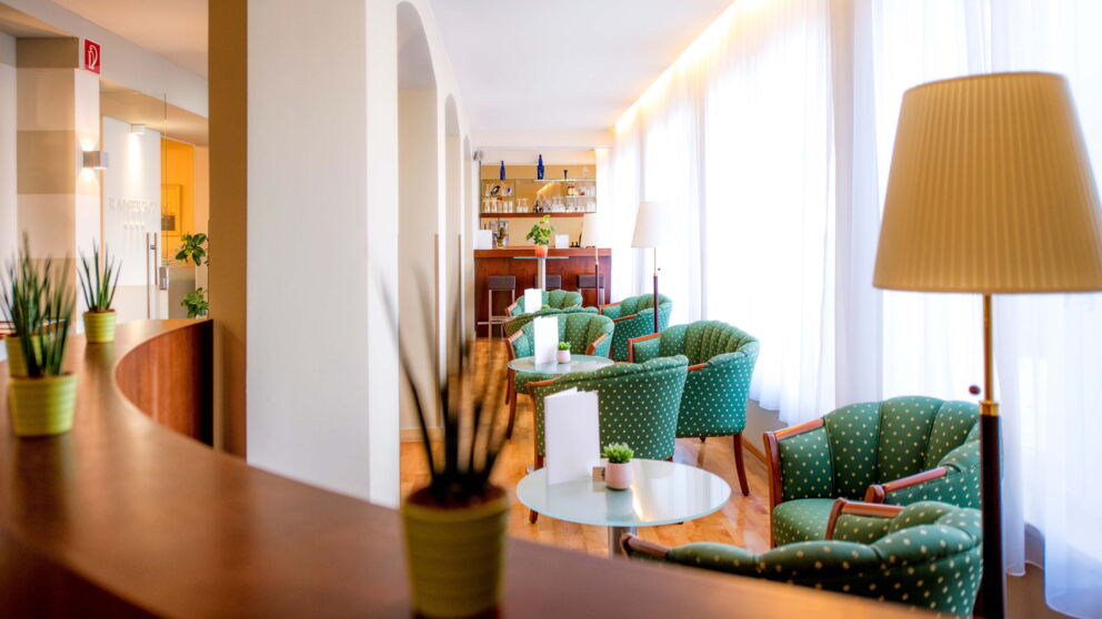 Gemütlicher Wartebereich an der Rezeption mit schönen grünen Sesseln