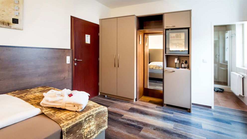 The single business room with wooden floor and box-spring bed at Hotel Der Kaiserhof