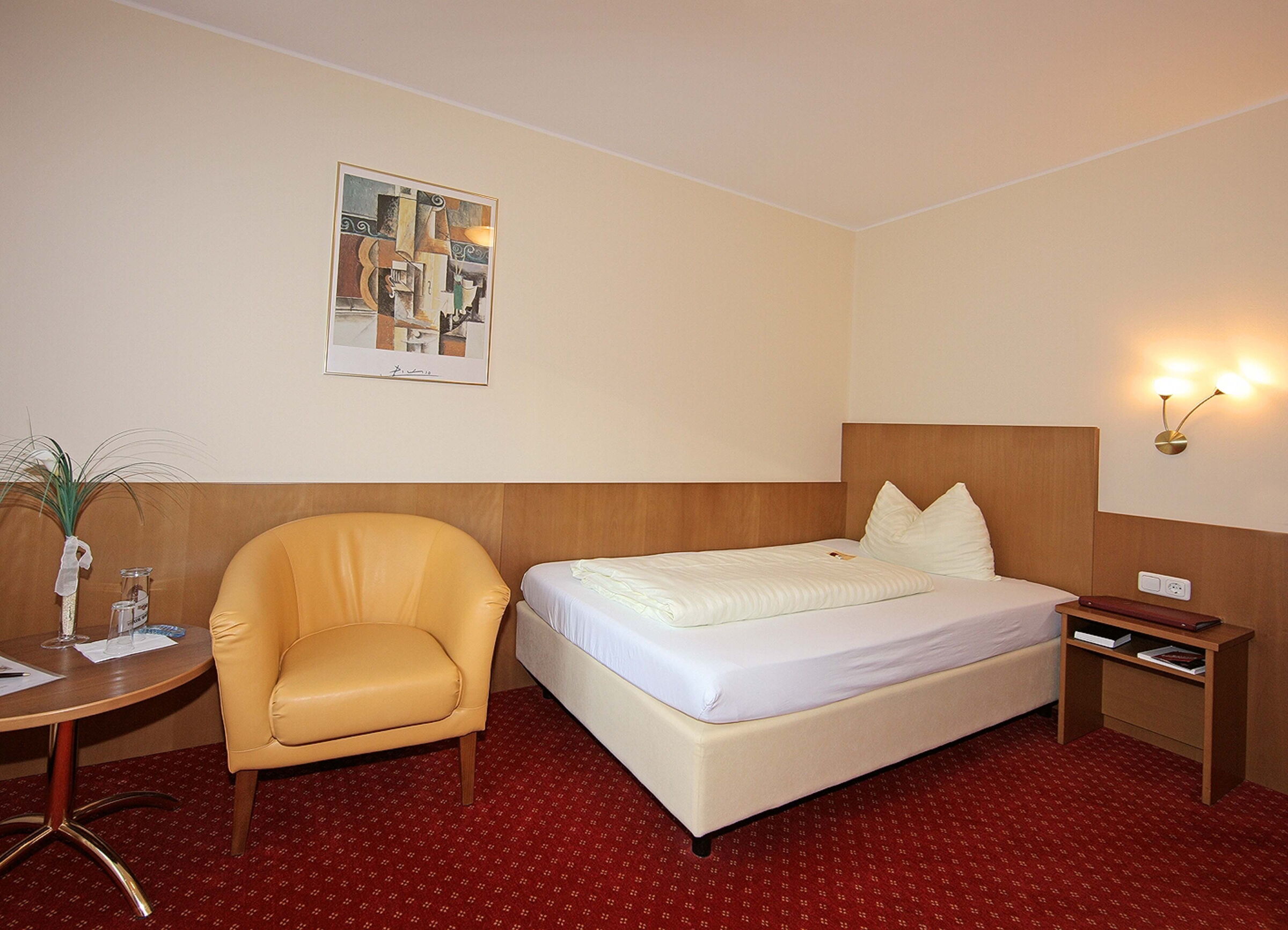 Das Classic-Einzelzimmer mit Boxspringbett und rotem Teppichboden im klassischen Stil im Hotel Der Kaiserhof