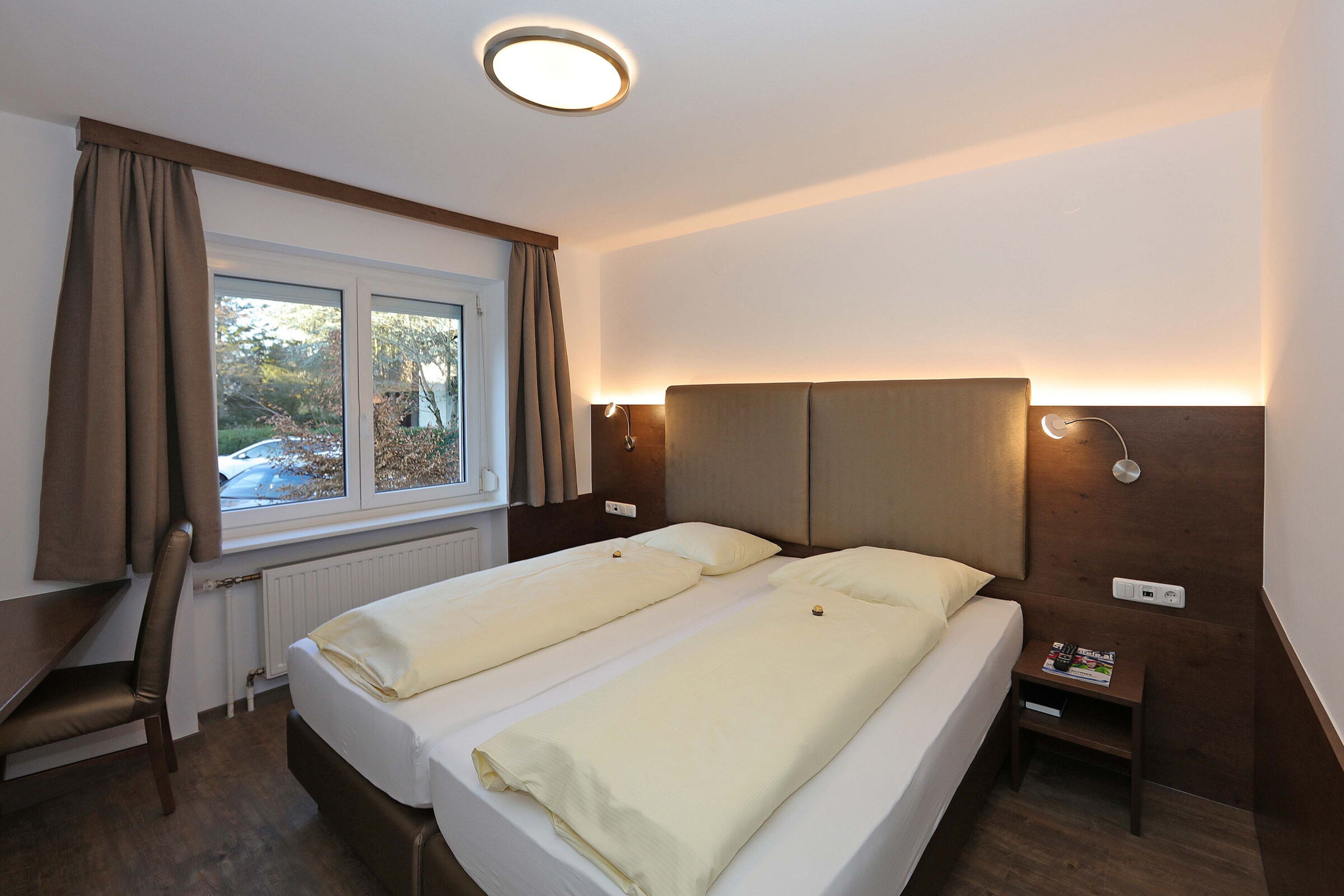 Modern double room with a large window and wooden floor